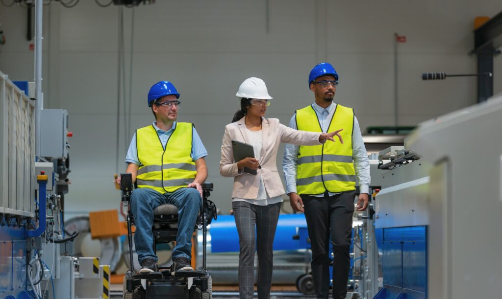 Group of warehouse workers talking to each other, one is in wheelchair