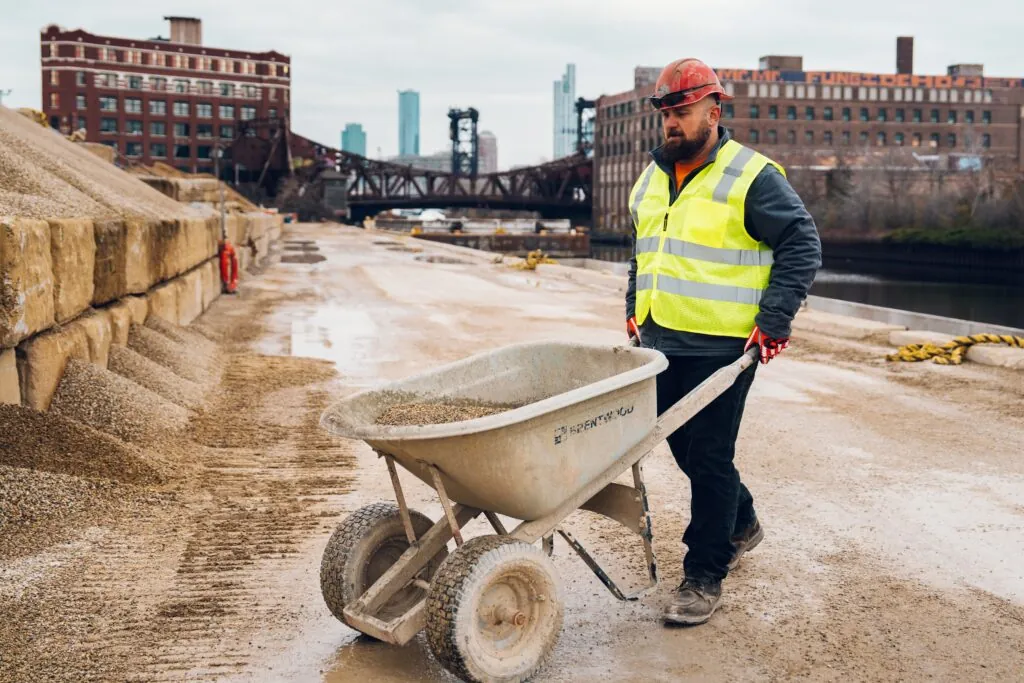 Construction worker onsite pushing wheelbarrow