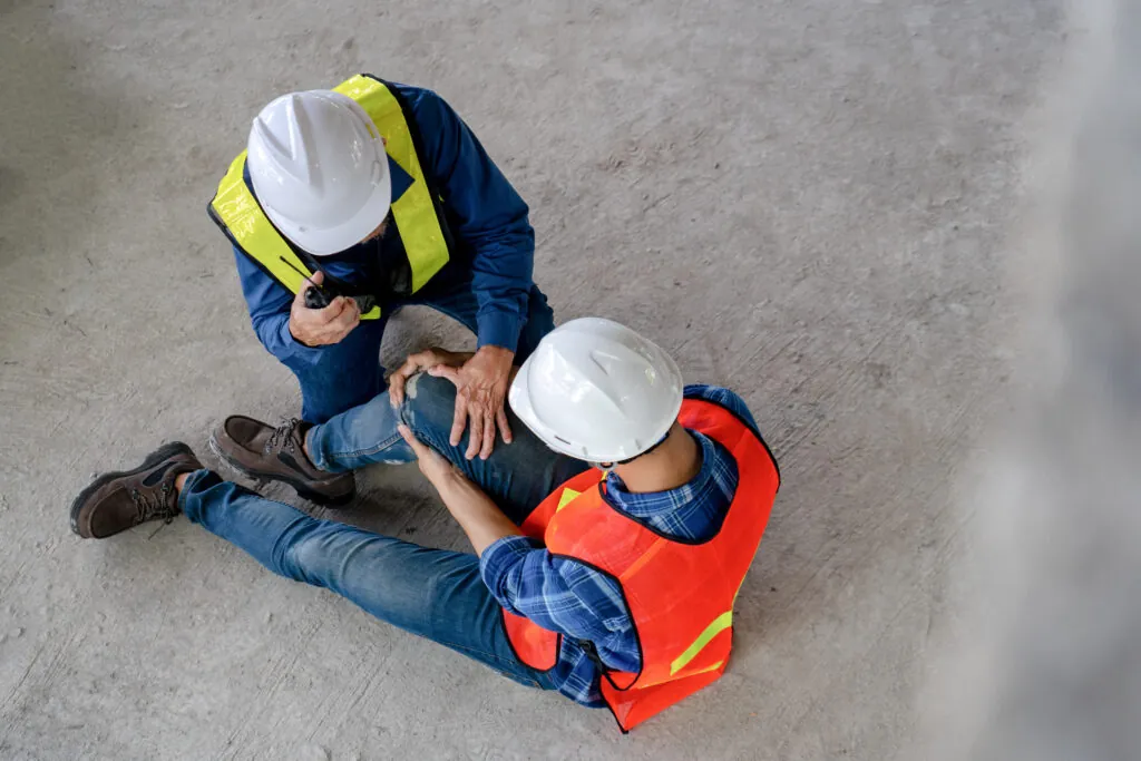 top view of construction workers after an accident suffering a knee injury from working at site