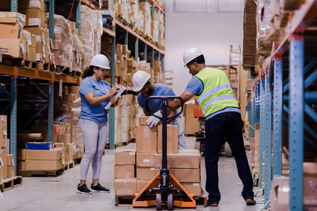 Female manager checks items off list as men load pallet